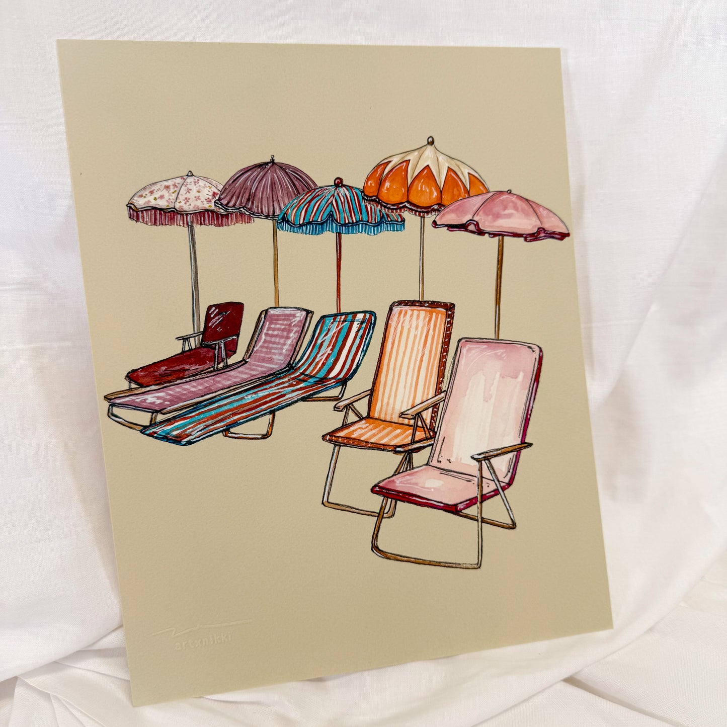 A beige colored wall art print featuring vintage colorful beach chairs and umbrellas