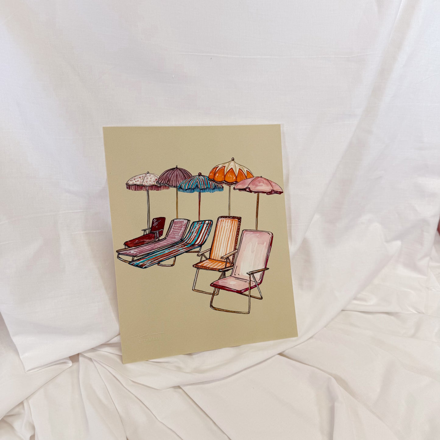 Illustration of lounge chairs and umbrellas on a beige background, placed on a white fabric surface.