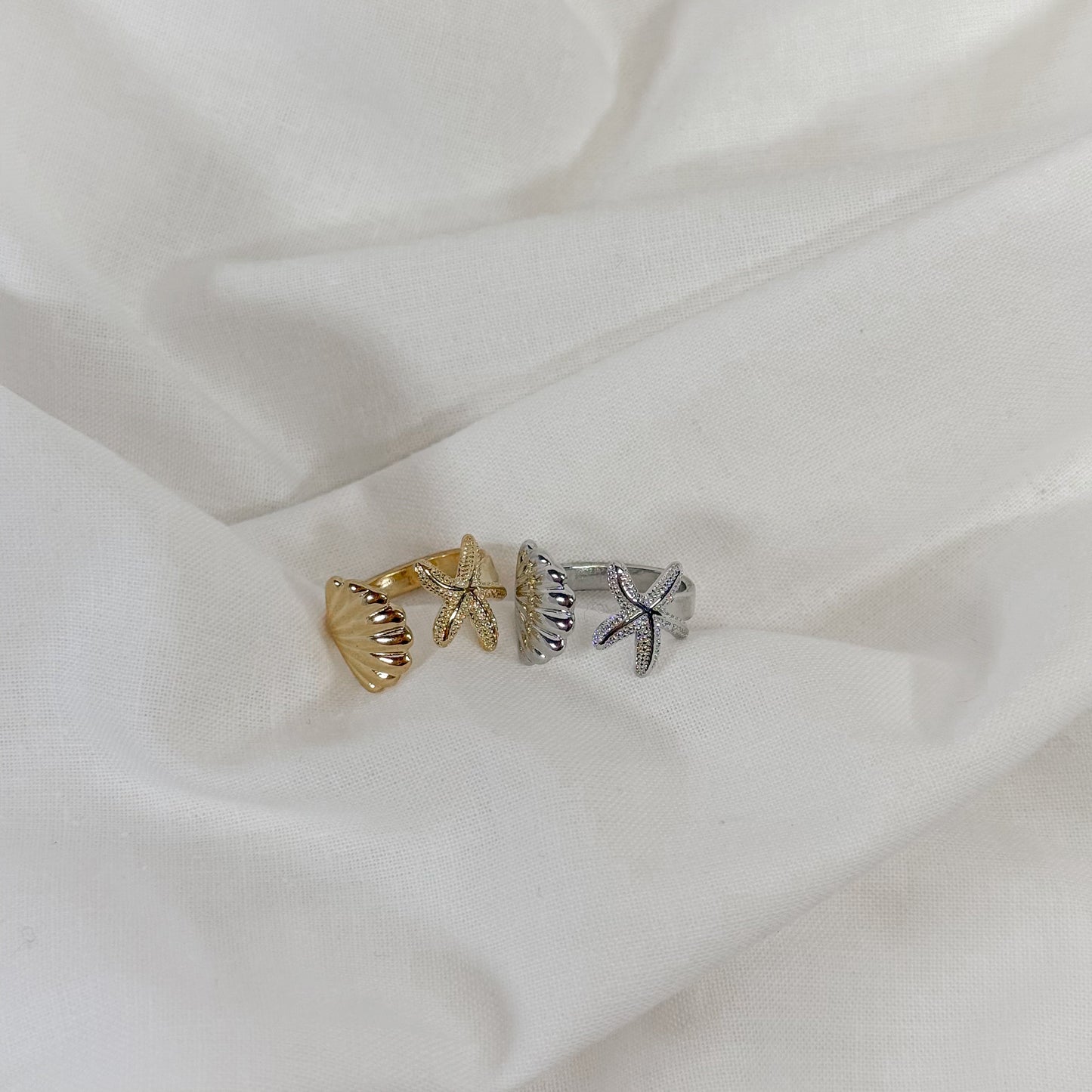 Two beach themed rings on a white fabric background
