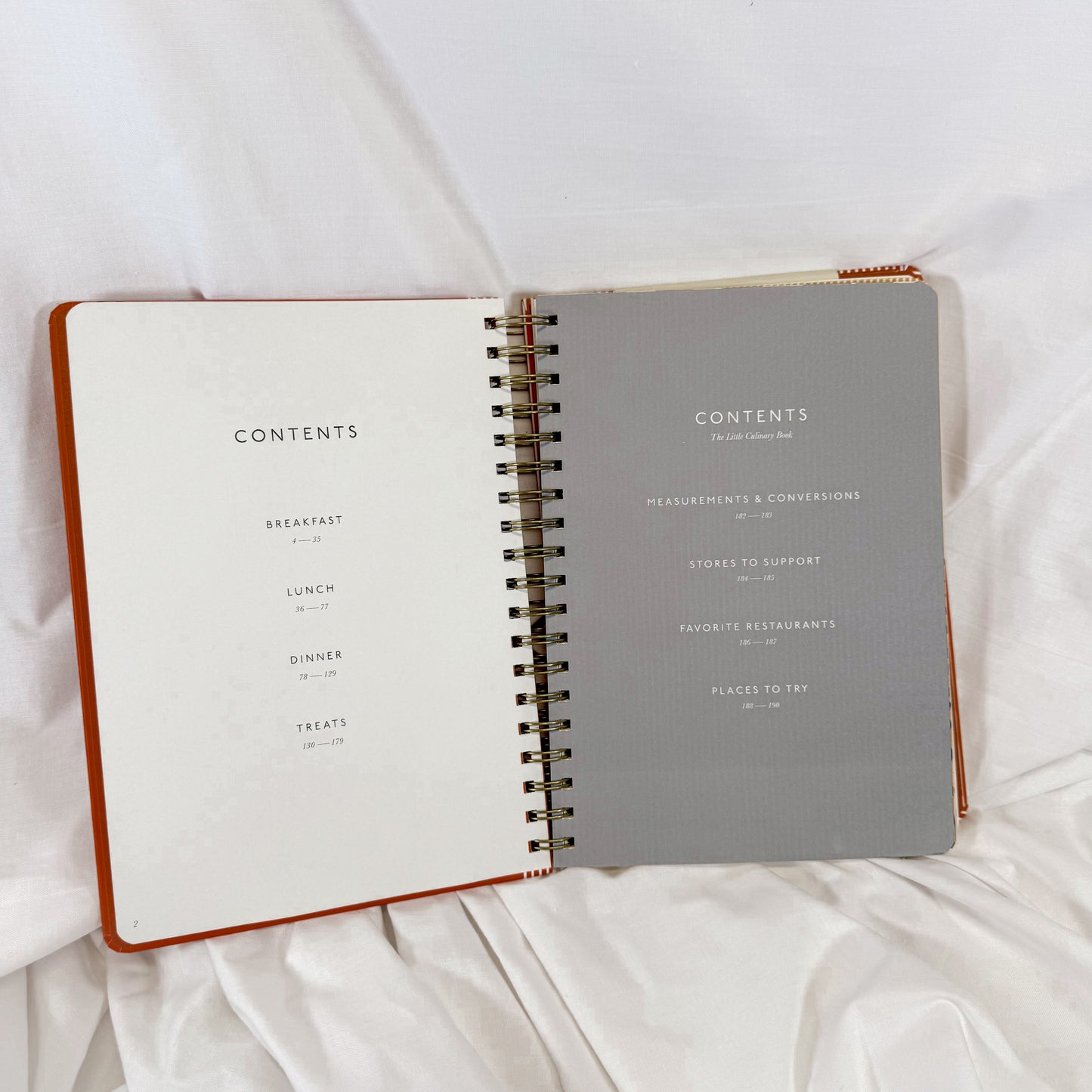 Open notebook with 'Contents' page on a white fabric background