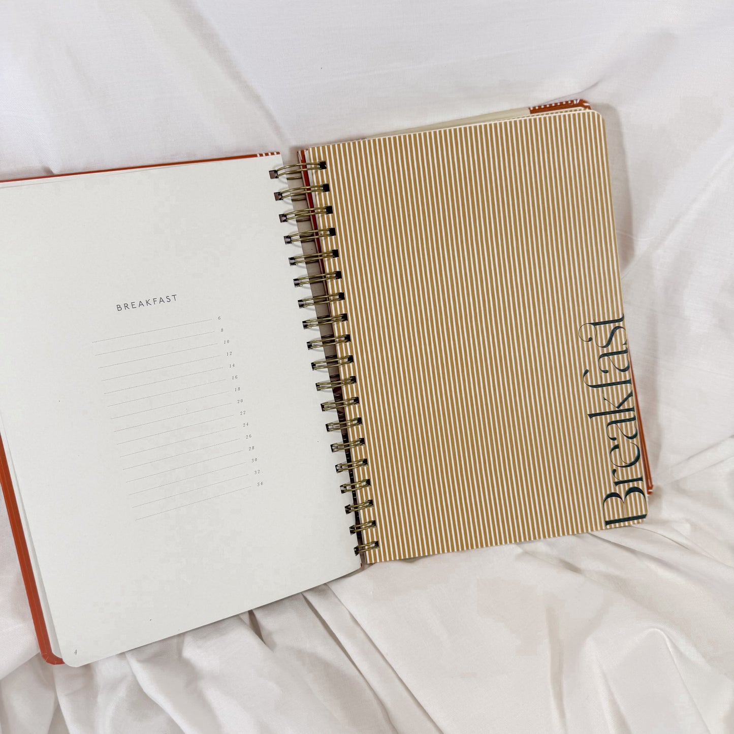 Elegant spiral-bound cookbook journal with modern wine and cheese artwork on the cover