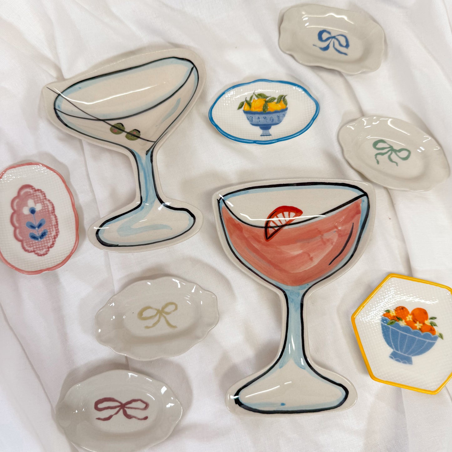 Girly jewelry dishes on a white fabric background