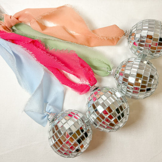 Colorful disco ball car mirror charms on a white background