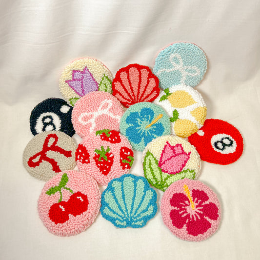 A collection of colorful handmade fabric cup holder inserts in various designs, displayed on a white surface.