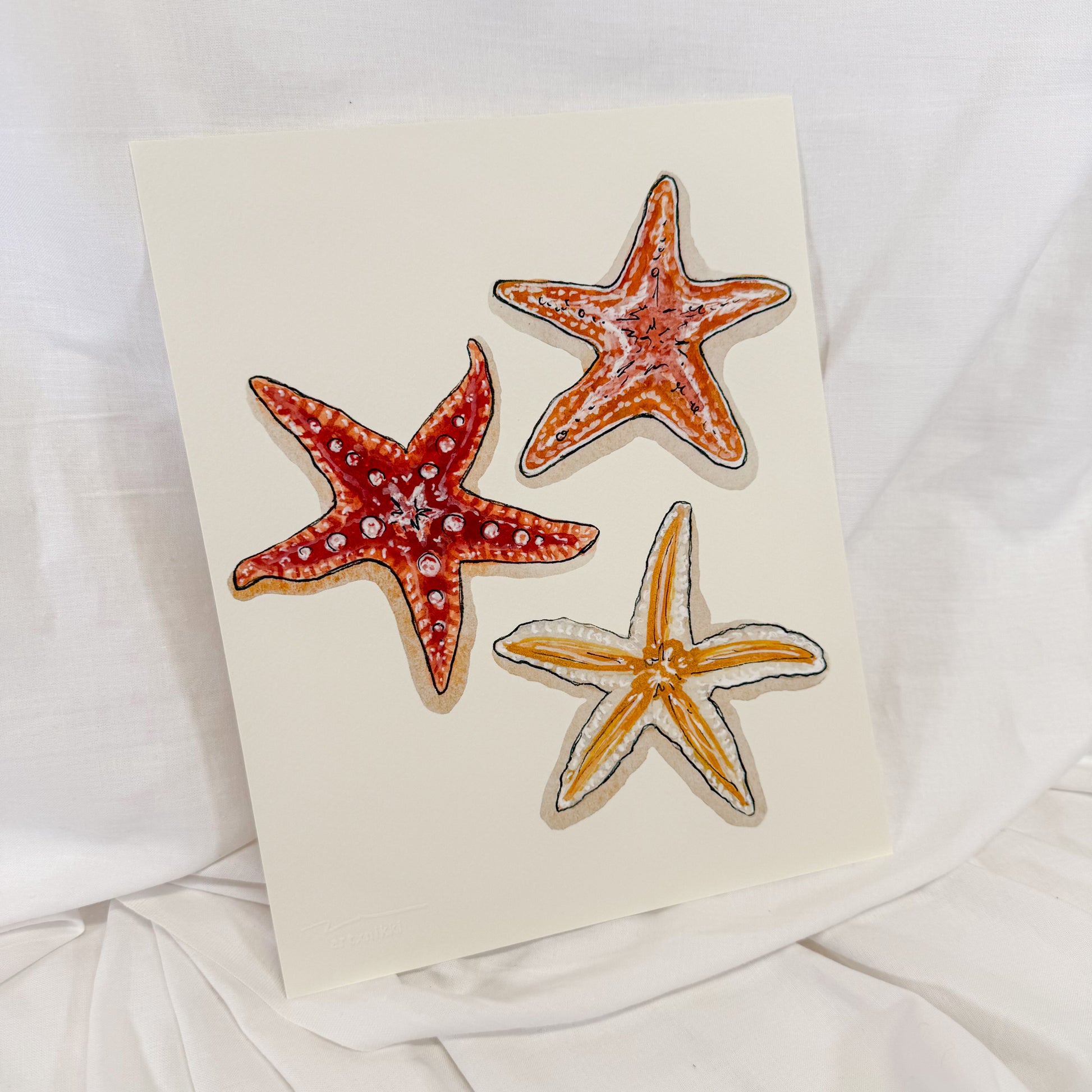 Cream colored wall art print featuring sunset colored starfish
