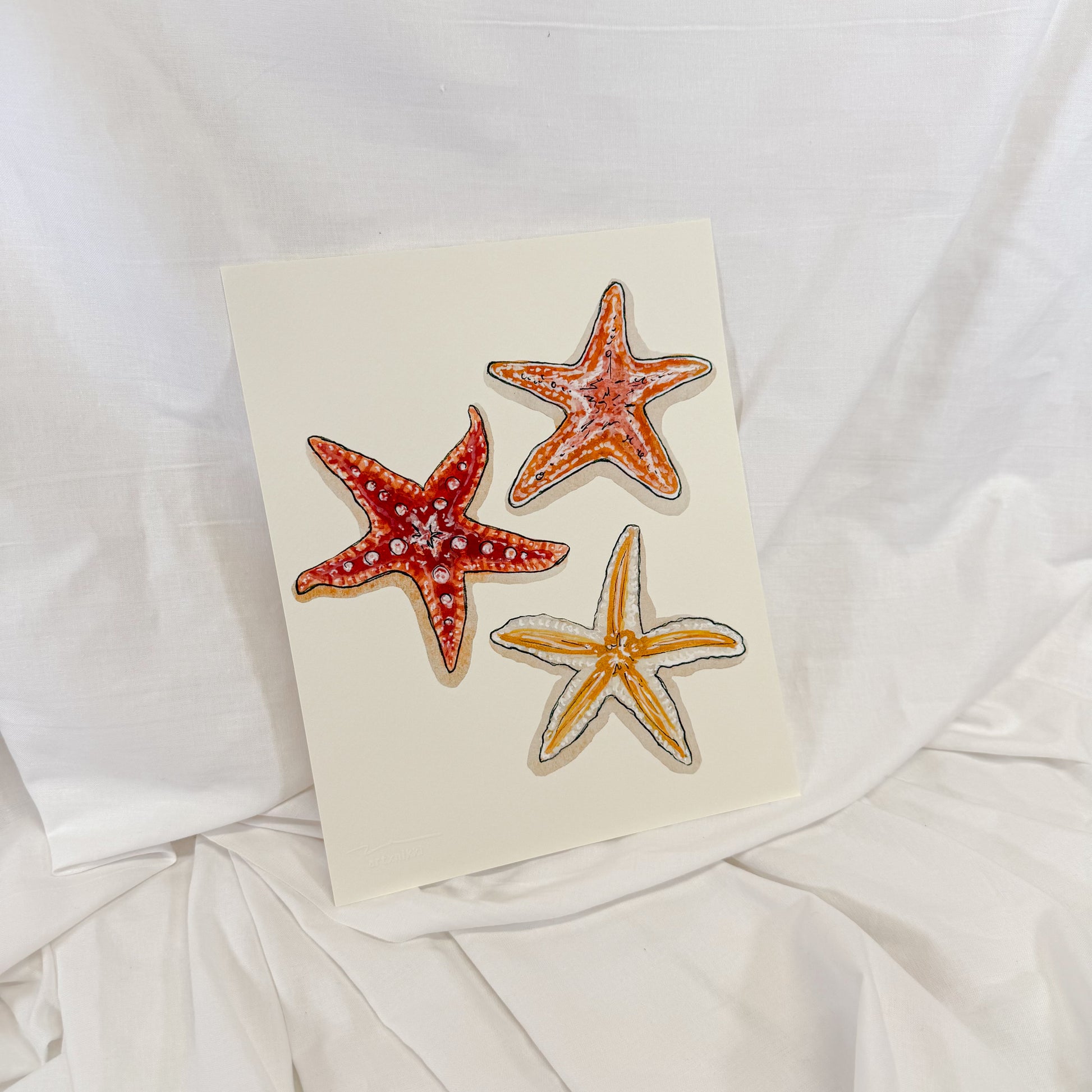 Three starfish painted onto a beige background