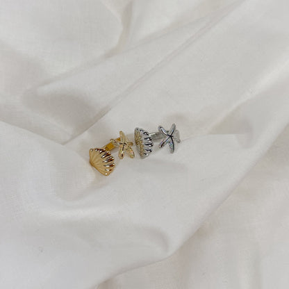Jewelry set with a starfish and shell charm on a white fabric background
