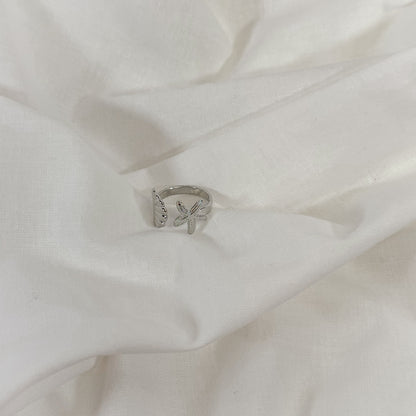 Silver ring with a shell design on a white fabric background