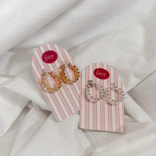Two pairs of earrings on pink and white striped cards with 'Gasp' branding on a white fabric background.