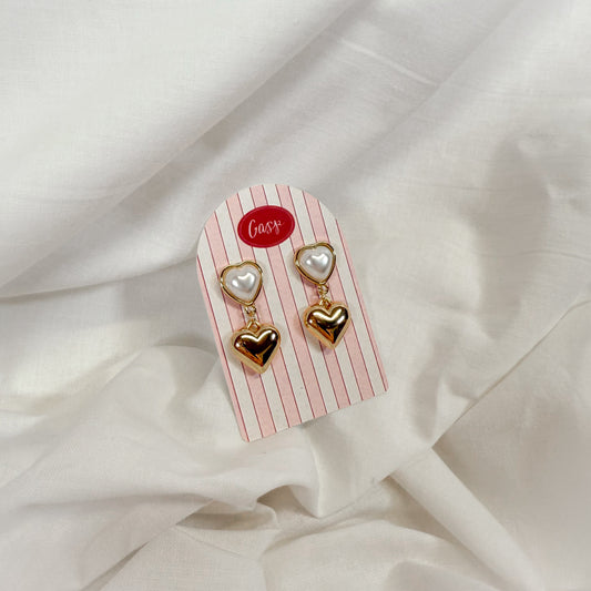 Heart-shaped earrings on a striped card with 'Gasp' branding on a white fabric background