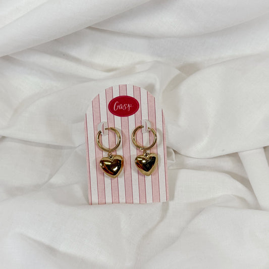 Gold chunky heart-shaped hoop earrings on a striped card with 'Gasp' logo against a white fabric background