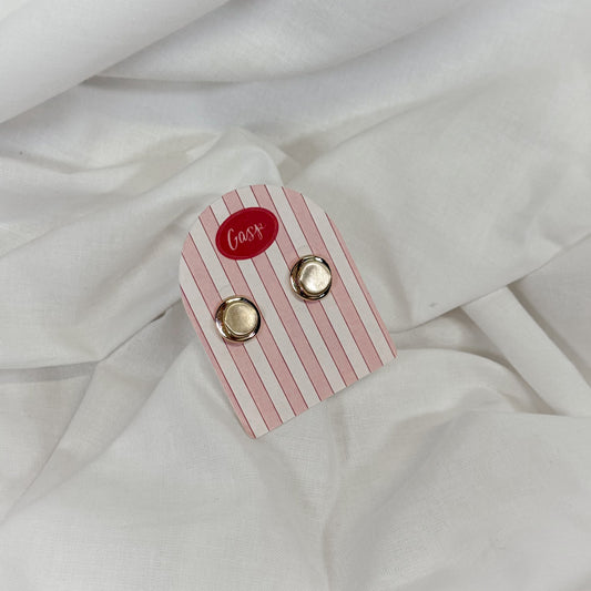 Round gold earrings on a pink and white striped card with 'Gasp' branding, placed on a white fabric background.