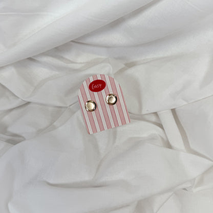 Chunky golf earrings on a pink and white striped card with 'Gasp' brand name, placed on white fabric.