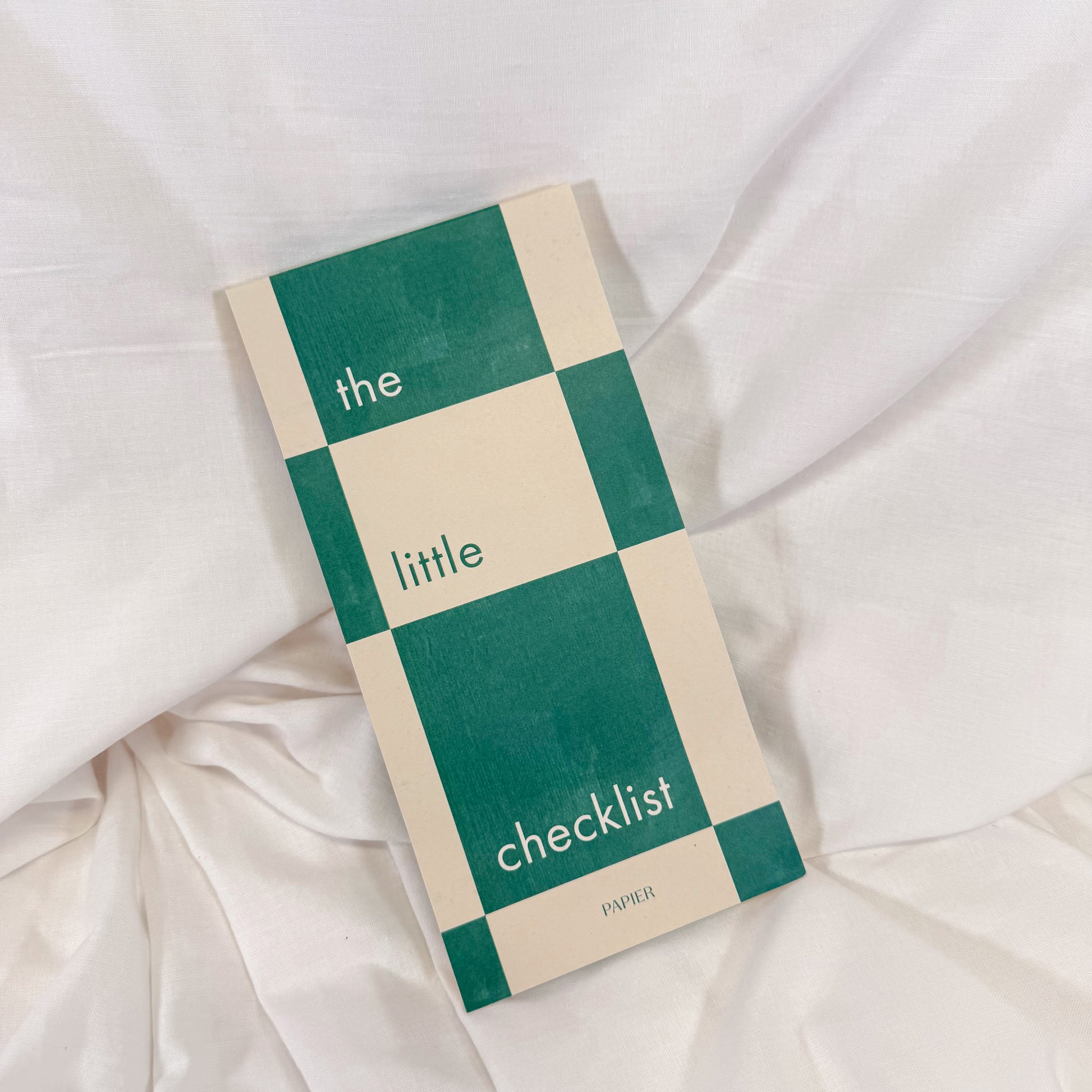 Top view of green and white checkered to-do list notepad on desk